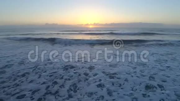 4k无人驾驶飞机在清晨日出时在佛罗里达大西洋海面上观看卫星冲浪海滩上平静的白浪视频的预览图