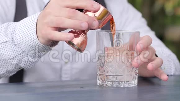 酒吧服务员在酒吧柜台上用冰块将果汁倒入杯中准备冷却鸡尾酒鸡尾酒会视频的预览图