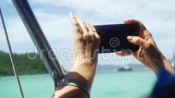 在度假期间在海滨使用移动智能手机的女性关闭3840x2160视频的预览图