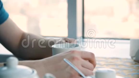 男性手和白色杯子男人拿着空白的杯子特写一位年轻帅哥喝杯咖啡的特写镜头视频的预览图