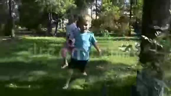 女孩和男孩赤脚在草地上奔跑视频的预览图