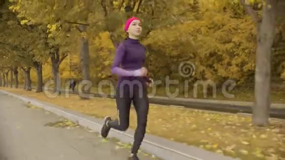 年轻的女运动员沿着马路跑视频的预览图