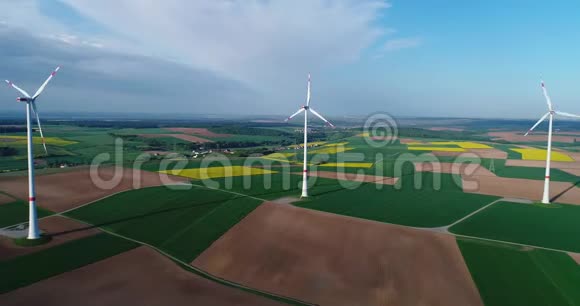 风电场矗立在绿色的田野上风力发电机在蓝天和浮云的背景下欧洲视频的预览图