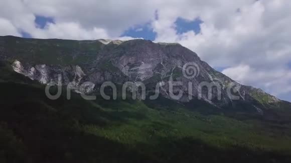 4k无人驾驶飞机拍摄的山边常绿森林和云视频的预览图