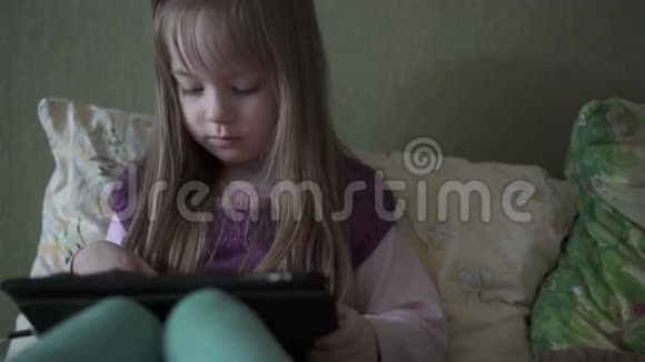 小可爱坐在沙发上玩平板电脑视频的预览图