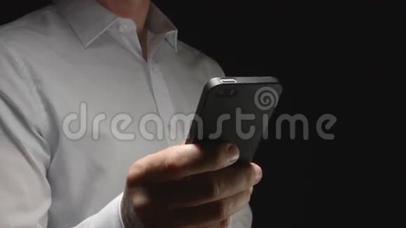 穿白色衬衫的人手拿智能手机触摸它半边视频的预览图