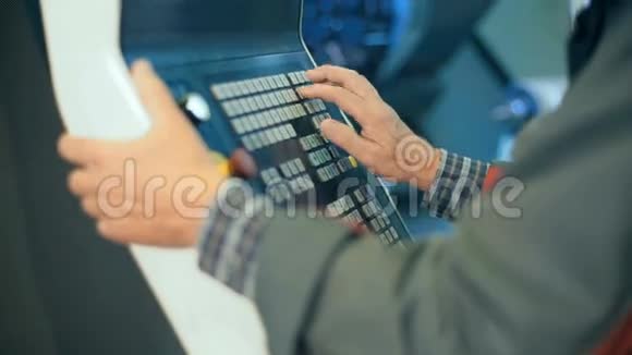 工人手在电脑数控可编程机器的控制面板上视频的预览图