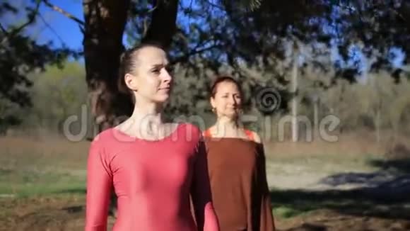 一起做瑜伽健身运动的战士姿势在森林日落视频的预览图