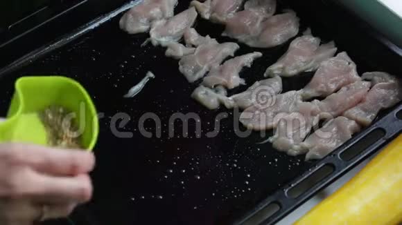 烹饪晚餐的配料女人把鸡片放在烤盘上撒上香料视频的预览图