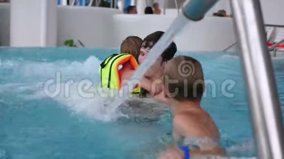 一位带着孩子的年轻父亲在水疗池里游泳在游泳池里放松和娱乐视频的预览图