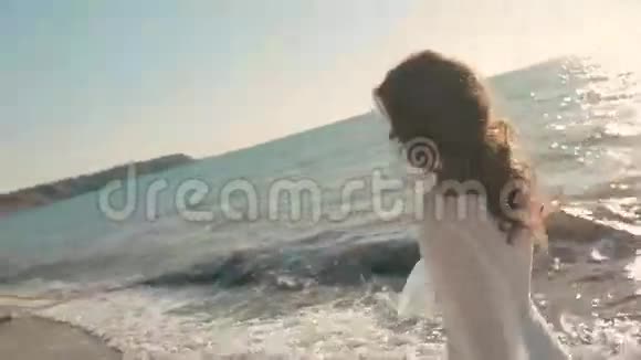 年轻漂亮的女孩跑在海边和视频的预览图