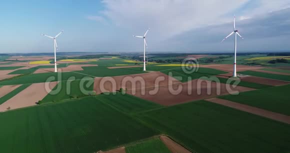 风电场矗立在绿茵场上风力发电机背景蓝天白云阳光明媚视频的预览图