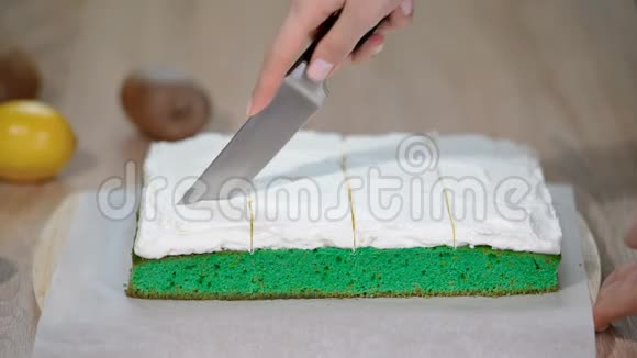 女人的手在切绿色蛋糕视频的预览图