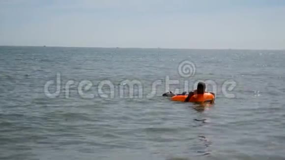 少年男孩在英国海边的充气床垫上漂浮视频的预览图