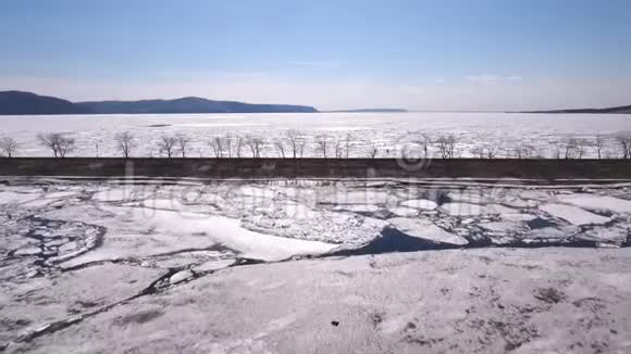 一架无人机飞过结冰的河流水和冰在结冰的河流上视频的预览图