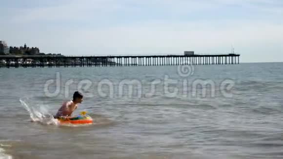 少年男孩在英国海滨充气床垫上漂浮视频的预览图