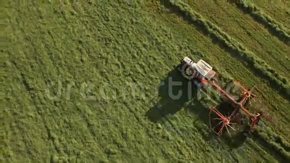 4K山上阳光明媚的一天拖拉机在田野上采集干草视频的预览图