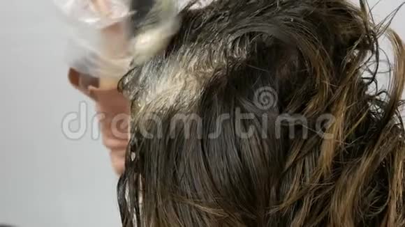 女性根上的白发这种头发本身就是用特殊的油漆和刷子在家里染发的视频的预览图