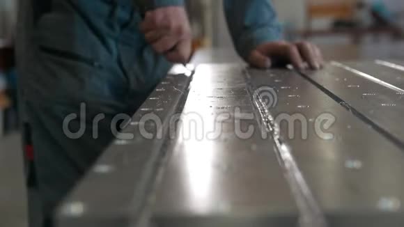 数控机械生产用刮刀去除金属细节毛刺的工人视频的预览图