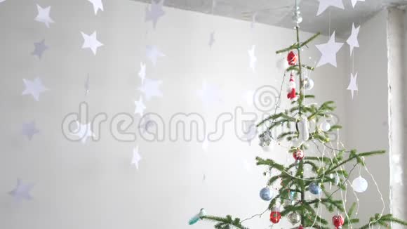 纸上的星星挂在窗户旁边的冷杉树旁边作为圣诞节内部的背景圣诞节的概念新视频的预览图