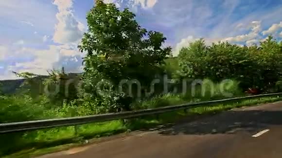 摄像机沿着乡间小路在丘陵景观中跟随着滑板车视频的预览图