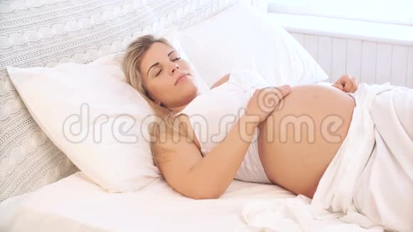 孕妇躺在床上梳头视频的预览图