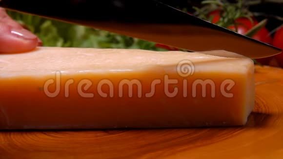 用刀子在木板上切割硬皮干酪视频的预览图