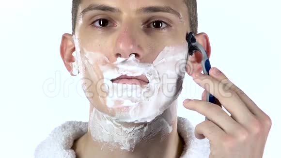 男人用剃刀刮脸颊白色背景慢动作视频的预览图