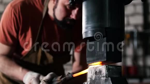 男铁匠在铁砧上锻造红铁小企业视频的预览图