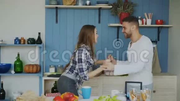 年轻的一对充满爱的年轻夫妇在假日的厨房里一起跳拉丁舞视频的预览图