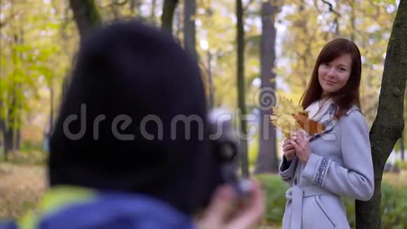 摄影师在户外拍一张年轻女子的照片视频的预览图