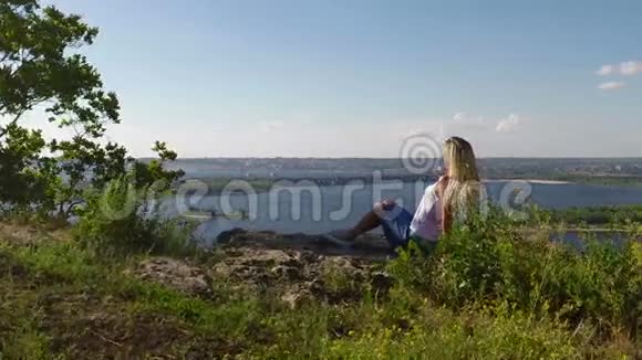 坐在伏尔加河岩石岸边的女人慢动作视频的预览图
