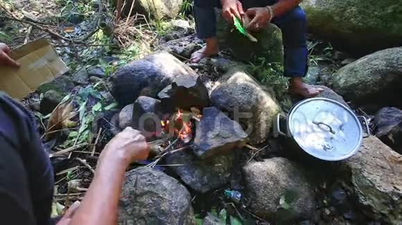 人们在山上森林的篝火旁煮饭视频的预览图