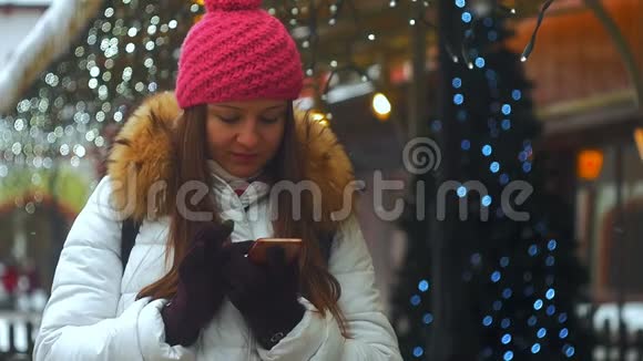 年轻女子微笑着面对冬天的城市使用电话视频的预览图