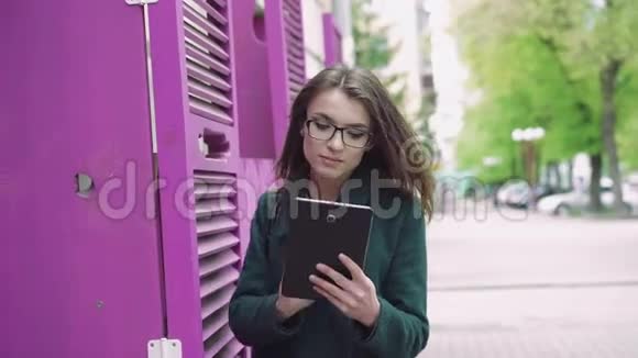 年轻女子在街上使用平板电脑视频的预览图