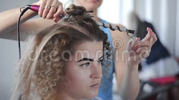 发型师通过烫发发型制作美容等方式为女性制作非洲卷发发型视频的预览图