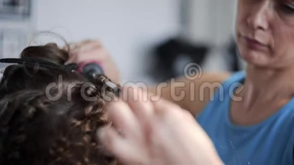 发型师通过烫发发型制作美容等方式为女性制作非洲卷发发型视频的预览图