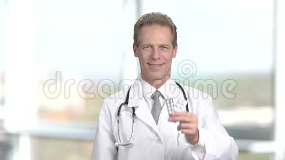 药剂师穿白色制服显示药丸视频的预览图