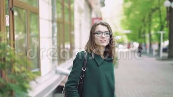 一个可爱的年轻女子站在街上对着镜头微笑4K视频的预览图