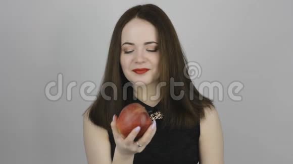 快乐的年轻女人吃红苹果视频的预览图