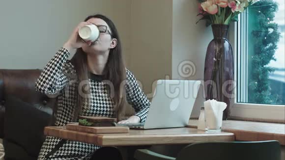 在咖啡馆里午休的女人喝咖啡用笔记本电脑视频的预览图