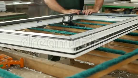 生产制造pvc窗男工装配pvc型材窗紧固铰链零件视频的预览图
