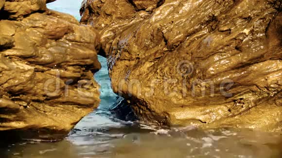 海浪拍打在石滩上阳光明媚的夏日海浪拍打着岩石视频的预览图