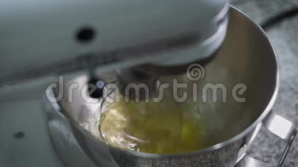 搅拌机搅拌蛋清用于在面包店厨房的金属碗中制作奶油专业设备视频的预览图