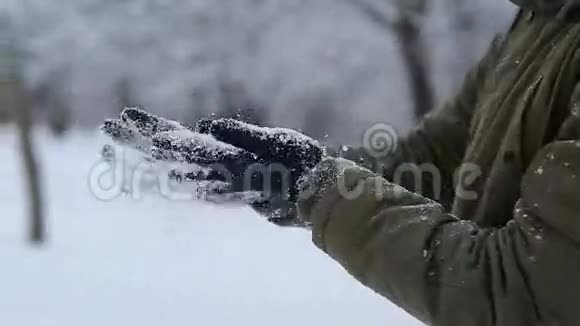 双手戴着手套在冬天的室外摇雪视频的预览图