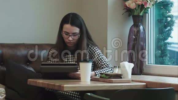 商务女性午休时在咖啡馆或餐馆工作带平板电脑视频的预览图