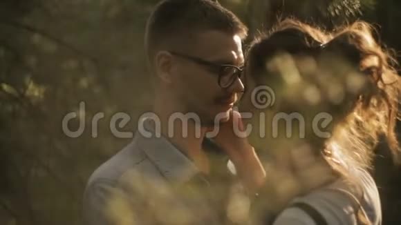 一对美丽的年轻夫妇在森林里接吻视频的预览图