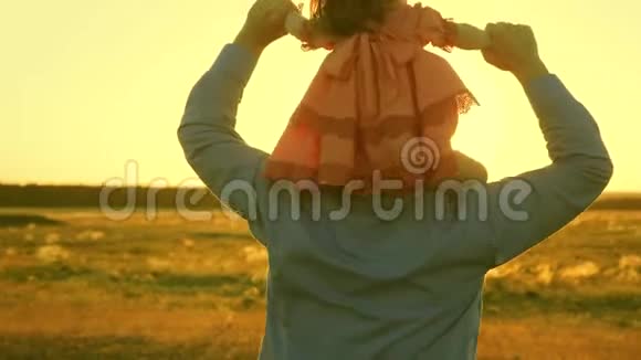 父亲带着女儿走在夕阳下的肩膀上爸爸背着心爱的孩子视频的预览图