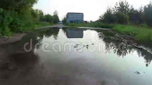 汽车在颠簸的道路上行驶穿过一个巨大的水坑从车上看视频的预览图