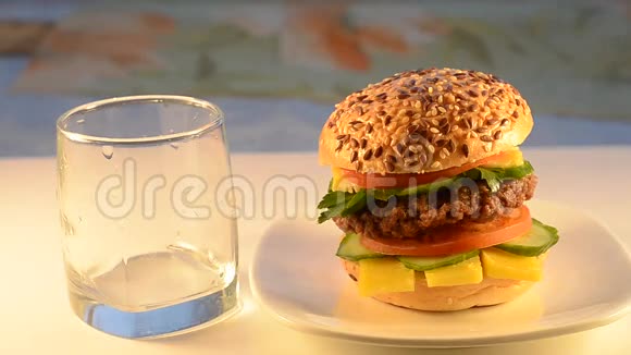 盘子里的汉堡和番茄汁倒入玻璃杯里视频的预览图